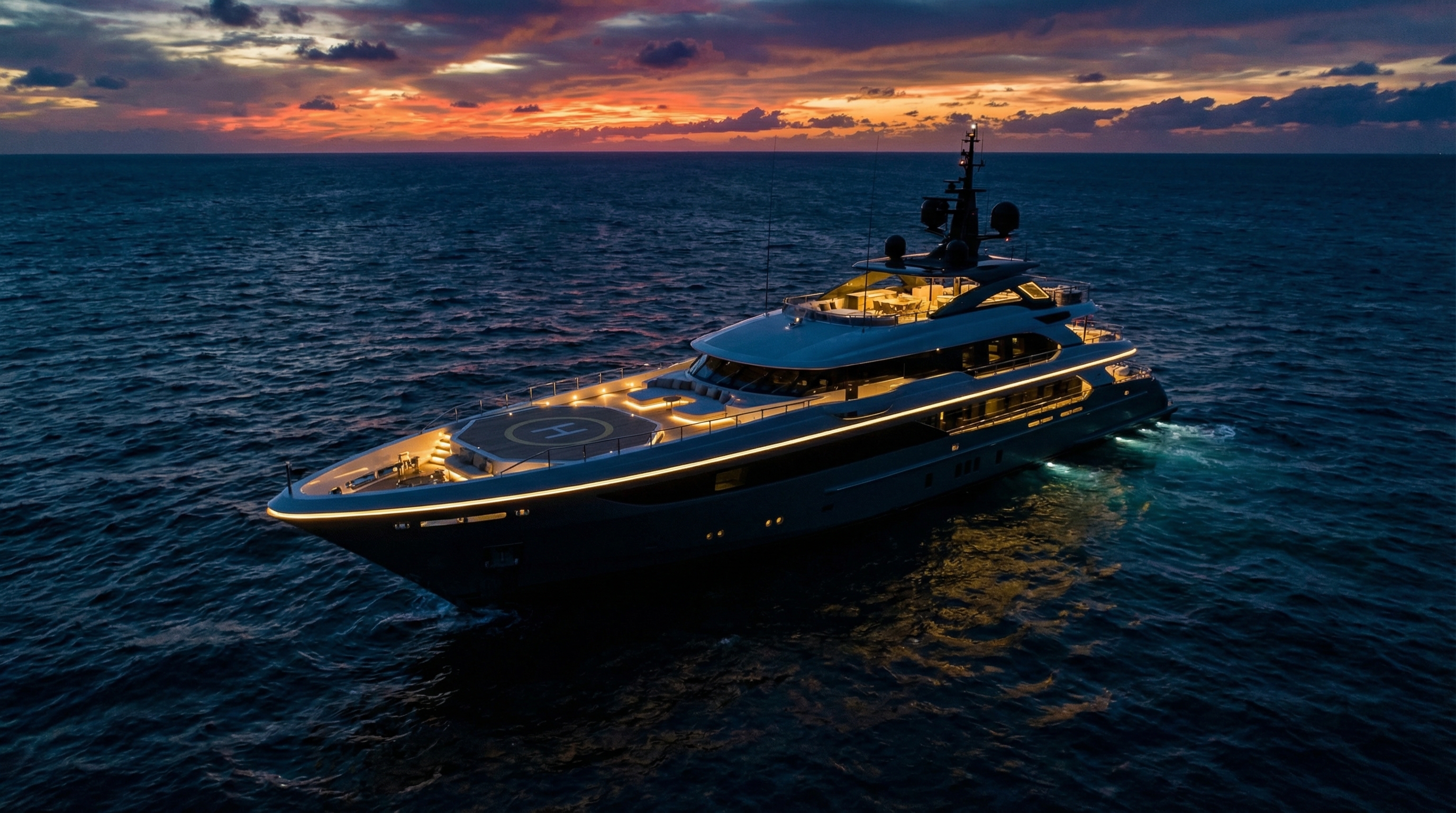 Luxury superyacht at dusk with security lighting along the deck